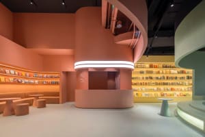 Modern bookstore with concrete walls, neon lighting, and shelves filled with books.