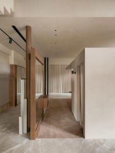 A modern corridor featuring marble floors, wooden walls, and white curtains.