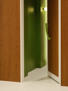 Modern green door handle with white lighting and wooden door.