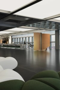 Modern office interior featuring metal beams, glass panels, and sleek design.