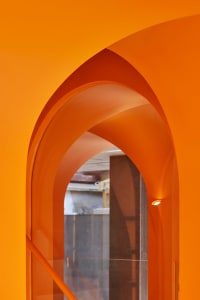Close-up of an orange acrylic architectural detail with a curved arch