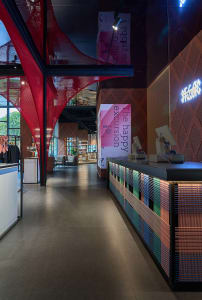 A modern retail storefront with metal lighting fixtures and red netting hanging from the ceiling.