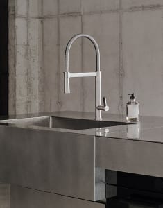 Concrete kitchen countertop with minimalist faucet and hand soap dispenser.