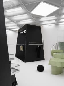 A modern clothing store with black and white interiors, featuring minimalist design and glass elements.