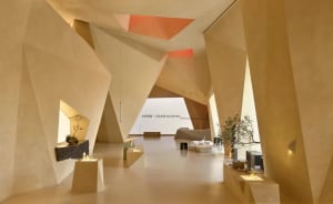 Modern interior space featuring geometric concrete walls and a hanging light fixture