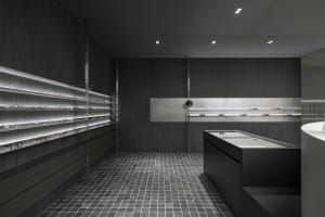 Minimalist eyewear store display with dark wood and glass materials