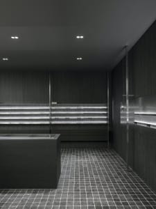 A minimalist industrial retail store featuring sleek metal shelves and concrete finishes.