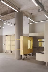 A modern office space with concrete columns and exposed roof beams.