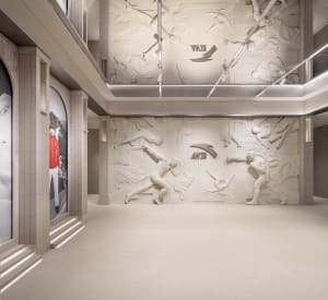 A spacious modern sports experience center featuring floor-to-ceiling art installations depicting athletes in motion.