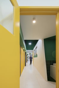 A brightly colored corridor with yellow walls and green accents.