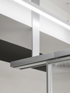 A modern office interior featuring glass panels and concrete structural elements.