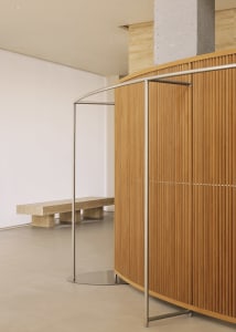 A minimalist office space featuring wooden paneling and concrete elements.