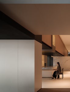 A modern residential kitchen with marble accents and concrete finishes.