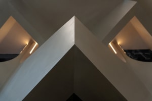 An interior design featuring modern concrete walls and geometric architectural elements.