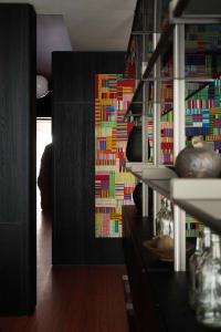 A colorful wall pattern with black furniture in a living room setting.
