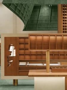 A modern retail shop interior with wooden displays and green architectural elements.
