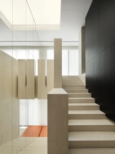 Minimalist interior design featuring modern concrete staircase with glass railings.