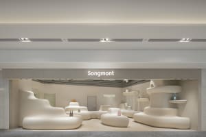 Modern minimalist retail storefront with white, curved furniture and signage for Songmont.