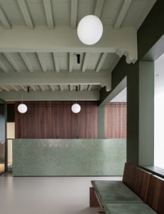 Modern, minimalist office lobby featuring a sleek, concrete reception desk.