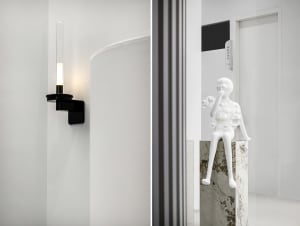 A modern interior design featuring sleek, white lighting fixtures mounted on a white wall.