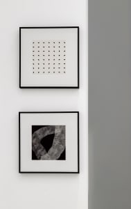Two minimalist black and white abstract art prints mounted on a white wall.