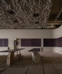 Minimalist cafeteria with terrazzo flooring and stone tables.