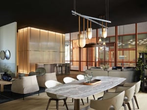 A modern living room featuring a marble dining table, leather chairs, and wooden flooring.
