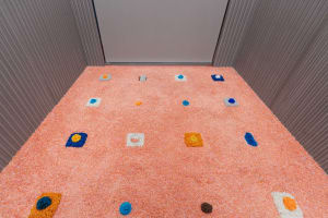A textured, industrial-style carpet with colorful patterns