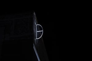 A glowing circular sign with the word 'Significant' attached to a building facade at night.