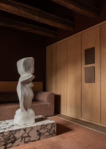 A minimalist living room featuring a white marble sculpture on a coffee table.