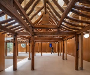 An interior design space featuring modern wooden architecture with exposed beams and natural light.