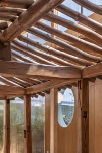 A modern interior featuring wooden beams and glass panels.
