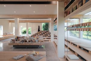 A modern library interior with wooden shelving and concrete flooring.
