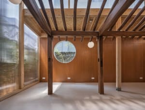 Interior space featuring modern design with wooden elements, large circular window, and glass partition.