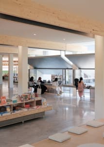 An open-plan modern workspace featuring wooden materials and minimalist design.