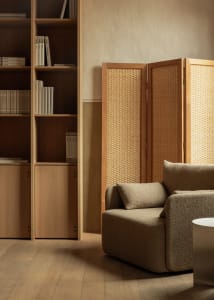 A minimalist living room featuring wooden furniture and textile accents.