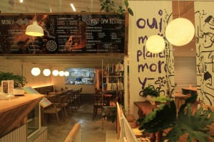 A modern café interior with wooden furniture and hanging lights.