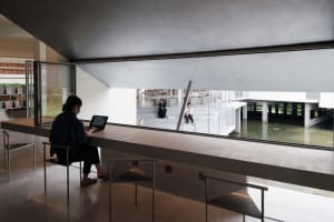 A modern library interior with concrete and glass elements.