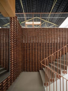 A modern building interior with a wooden wall and stairs.