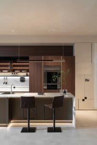 A modern kitchen interior with wooden cabinets and marble countertops.