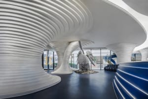 A sleek, modern corporate reception area featuring white and blue concrete design elements.