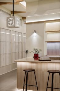 Modern bar counter with marble finish and stools.