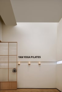 A minimalist yoga studio with glass paneling and white walls