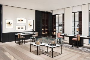A luxurious retail shop showcasing minimalist design with glass display cases, wood furniture, and metal accents.