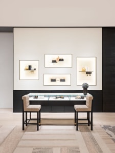 A modern retail display featuring a glass counter with various items on display, set against a polished concrete wall and sup
