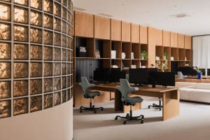 A modern office workspace featuring minimalist design and natural wood furniture.