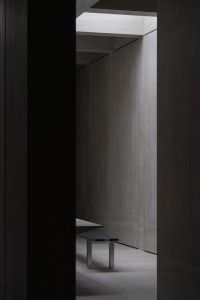 Minimalist interior space with wooden paneling and modern furniture.