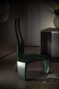 A sleek, modern metal stool with a grey finish, featuring curved lines and a unique shape.