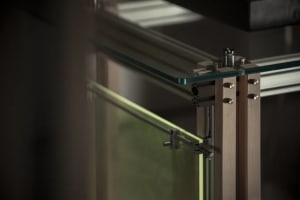 A modern glass balustrade with steel railings and wooden supports.