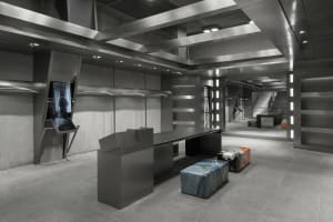Modern retail space featuring industrial design elements such as metal finishes, concrete walls, and large glass panels.